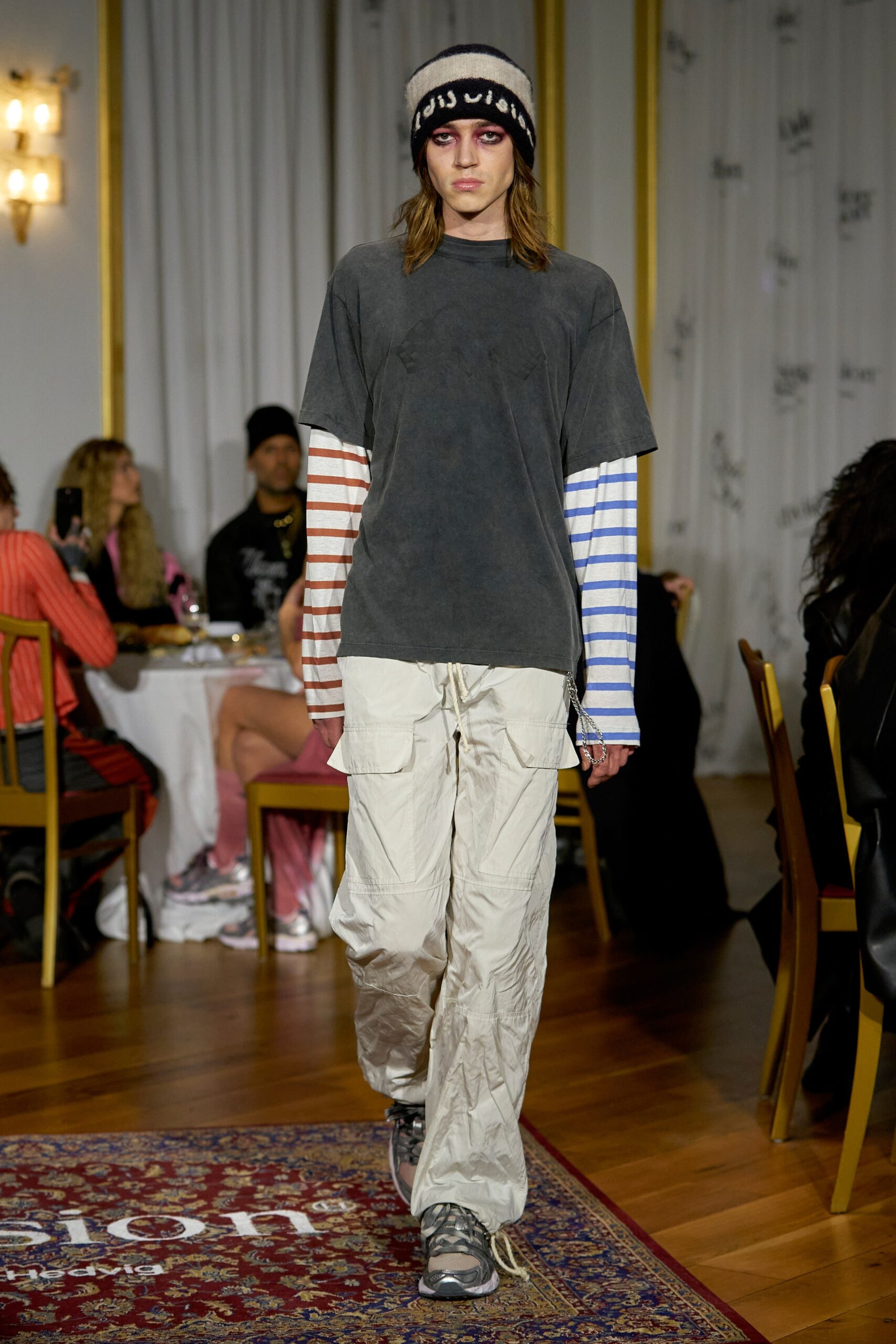A relaxed gray shirt with short sleeves and striped details paired with wide-leg pants.