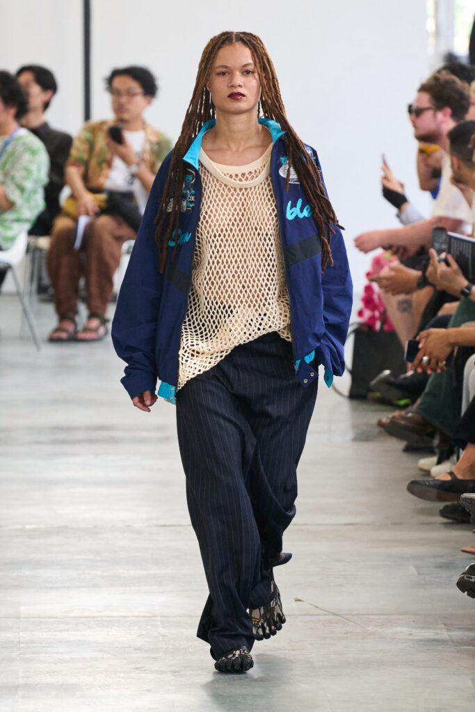 A relaxed blue jacket paired with striped pants, showcasing a casual yet stylish look.