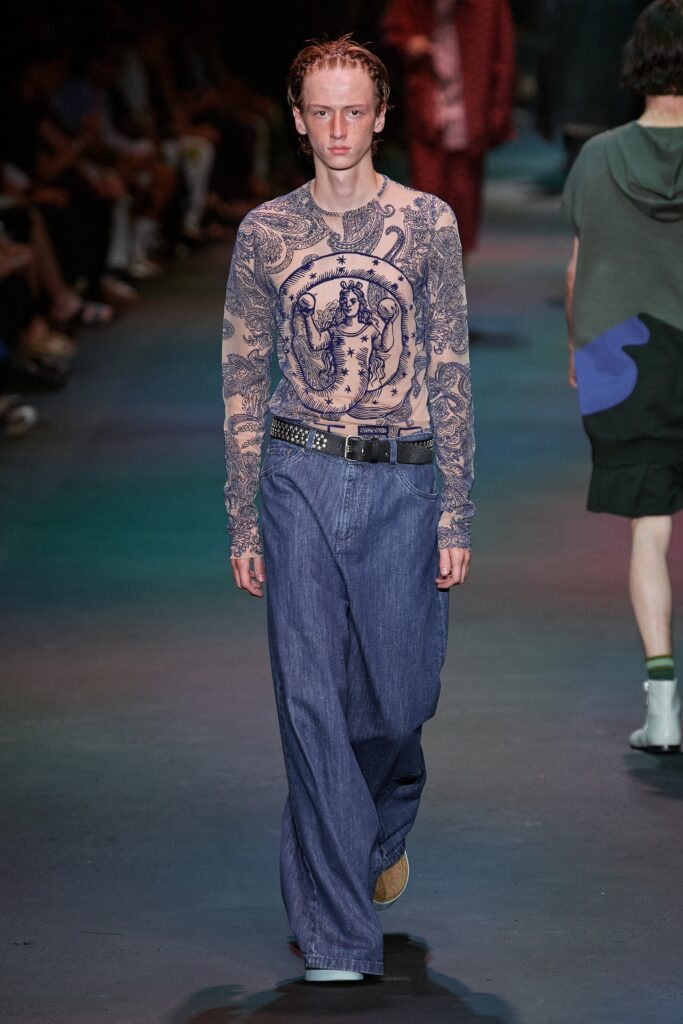 A relaxed blue printed long-sleeve shirt paired with comfortable denim pants.