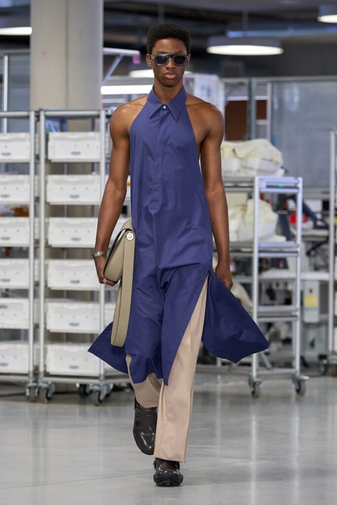 A relaxed blue cotton sleeveless dress with a high neckline and asymmetric design.