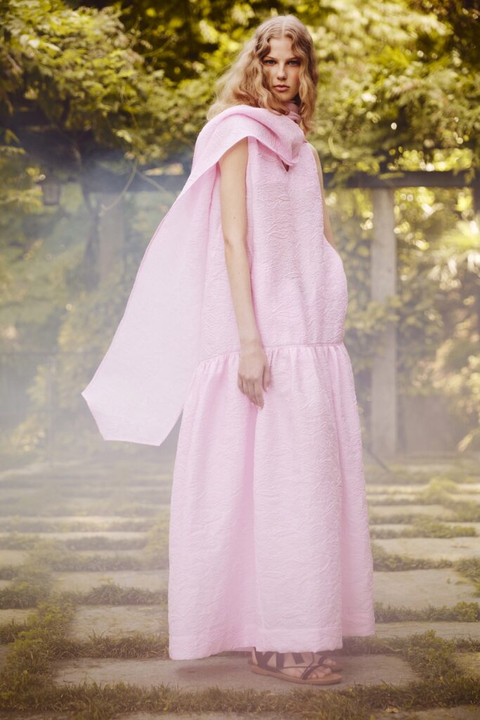 A relaxed pink cotton dress with a high neckline and tiered design.
