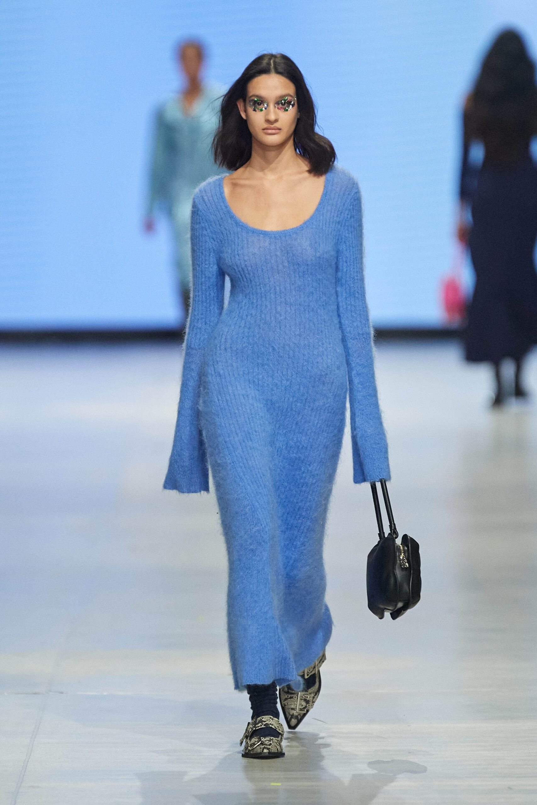 A fitted blue wool dress with long sleeves and a scoop neckline.