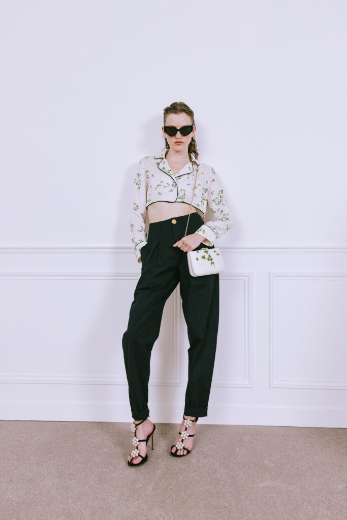 A relaxed white floral long-sleeve shirt paired with high-waisted black pants.