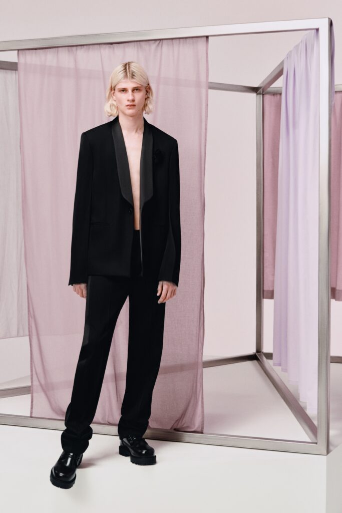 A tailored black suit with a collared long-sleeve jacket and buttoned details.
