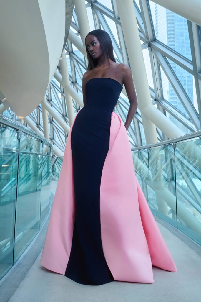 A fitted strapless gown featuring an asymmetric design in black and pink silk.