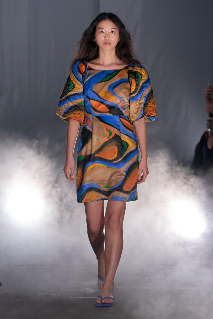 A fitted multicolor silk dress with short sleeves and an asymmetric design.