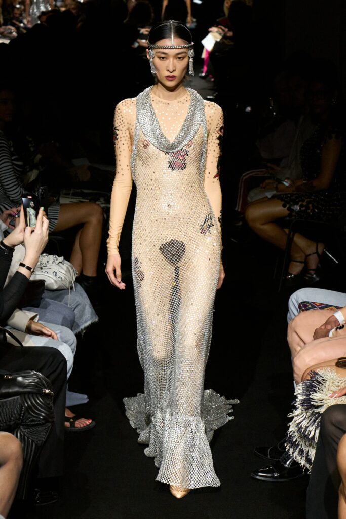 A fitted silver mesh dress with a V-neckline and flared silhouette.