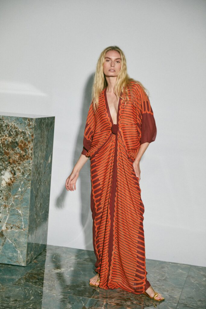 A relaxed orange and brown printed dress with long sleeves and a V-neckline.
