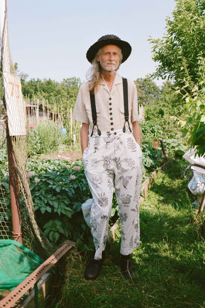 A relaxed beige short-sleeve collared shirt paired with white printed pants.