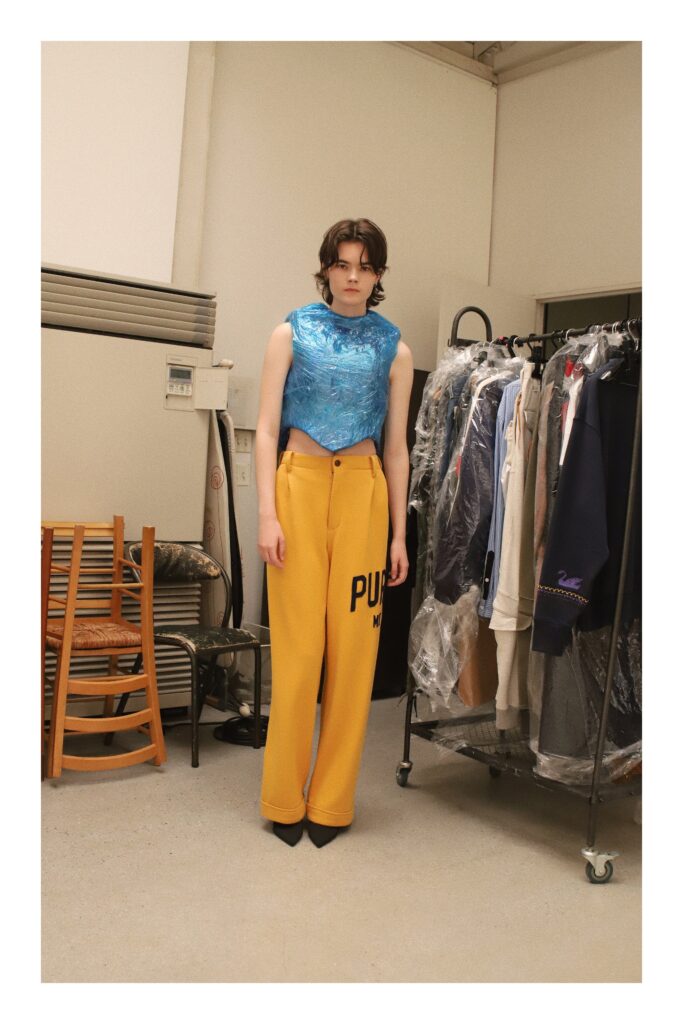 A fitted blue silk top paired with wide-leg yellow pants, creating a vibrant and stylish look.