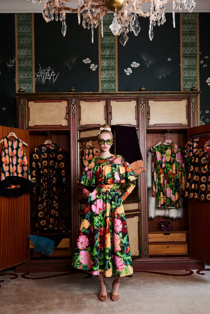 A fitted multicolor floral dress with long sleeves and a V-neckline featuring a flared silhouette.