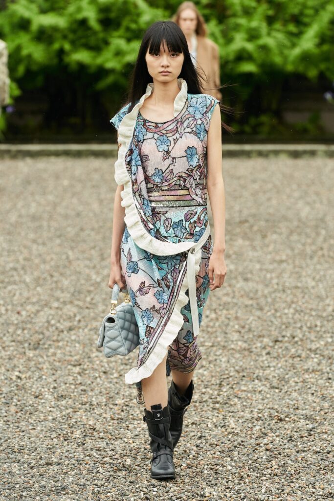 A fitted multicolor dress with a V-neckline and ruffled details, featuring a flared silhouette.