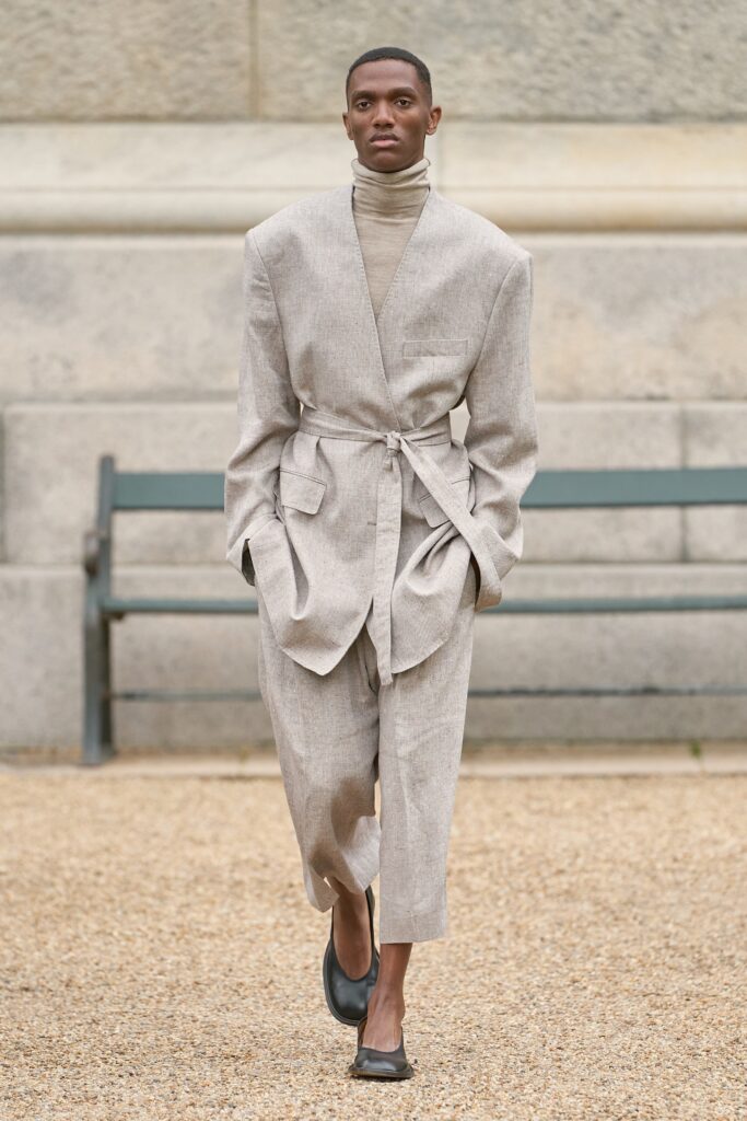 A relaxed beige linen suit with a belted design and long sleeves.