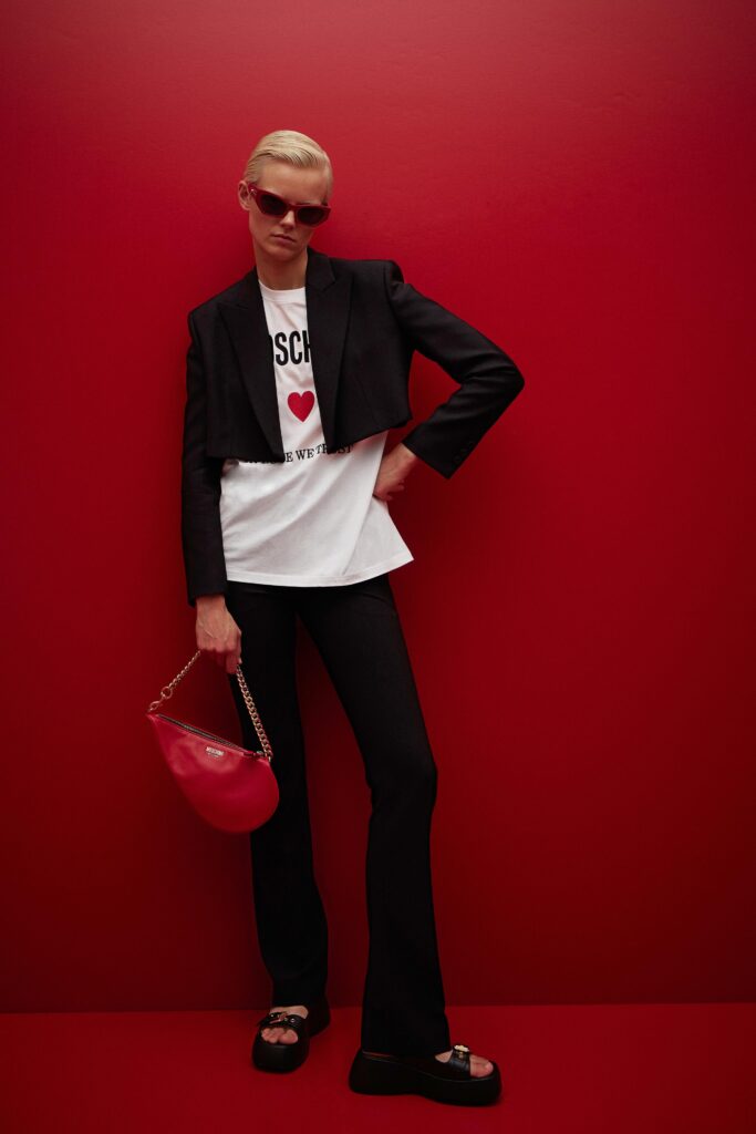 A fitted black blazer paired with a white printed top and black pants.