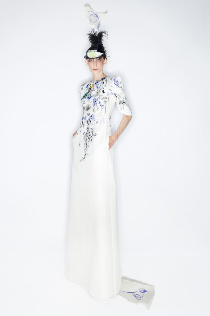 A fitted white silk dress with short sleeves, high neck, and intricate embroidery.