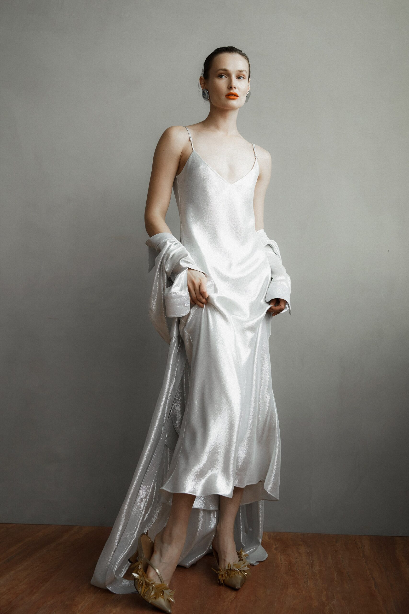 A fitted white silk dress with a V-neckline and a stylish slit detail.