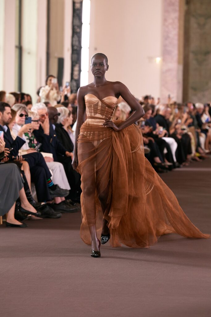 A fitted brown silk strapless dress with an asymmetric layered design.
