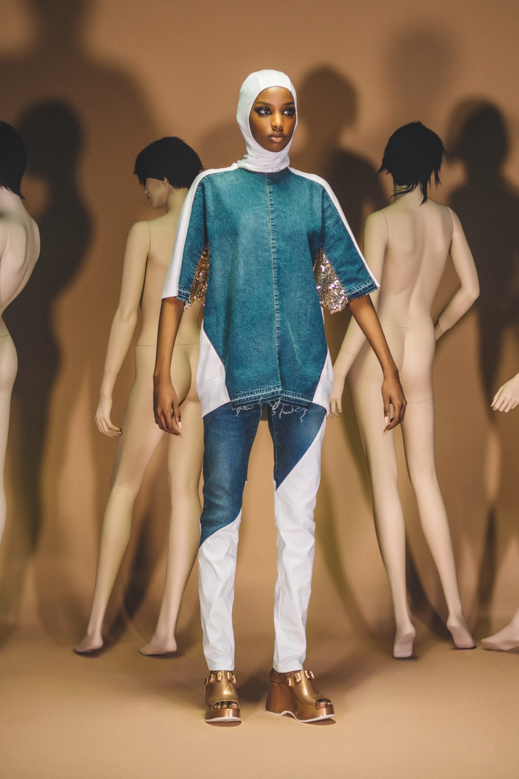 A relaxed-fit asymmetric denim top with short sleeves paired with white pants.