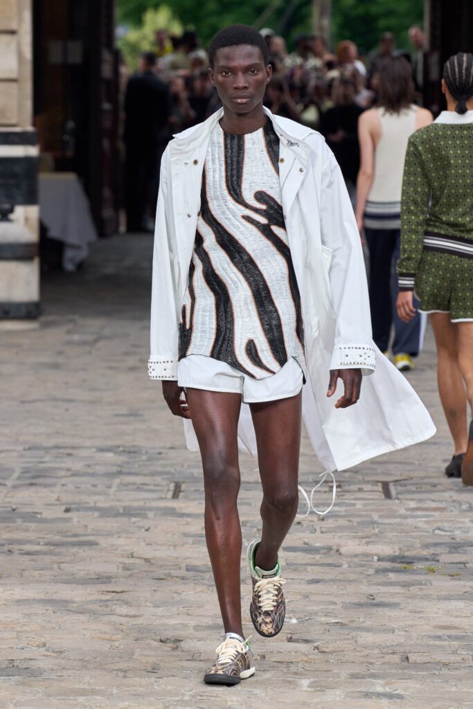 A relaxed white coat paired with a short-sleeve multicolor printed top.