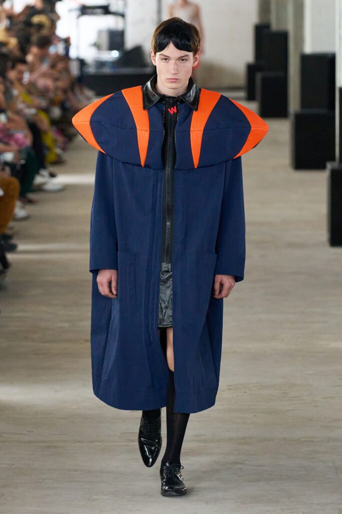 A relaxed blue cotton coat with long sleeves, a collared design, and asymmetric detailing.