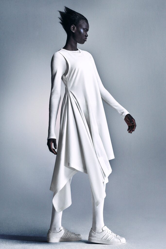 A relaxed white sleeveless dress with a high-neck and asymmetric design.