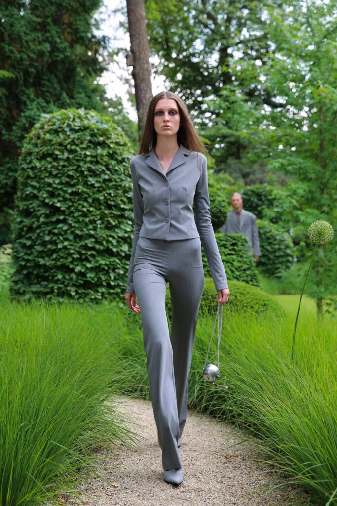 A fitted gray blazer with long sleeves and a collared neckline paired with straight-leg pants.