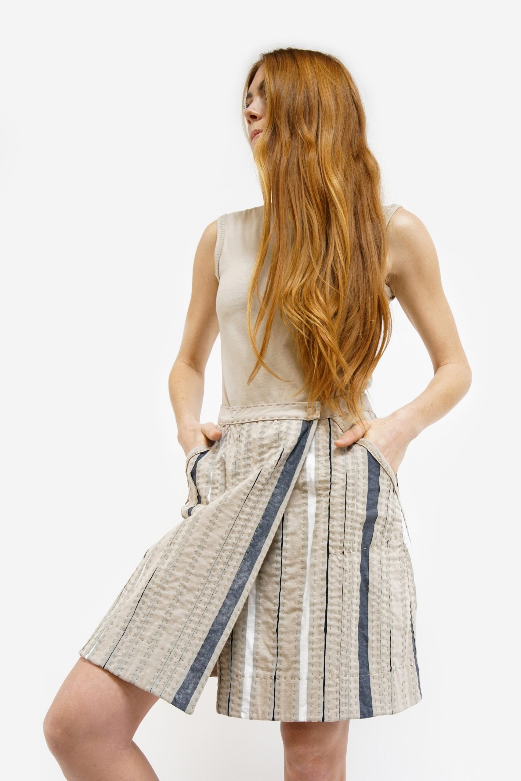 beige fitted sleeveless top and pleated skirt