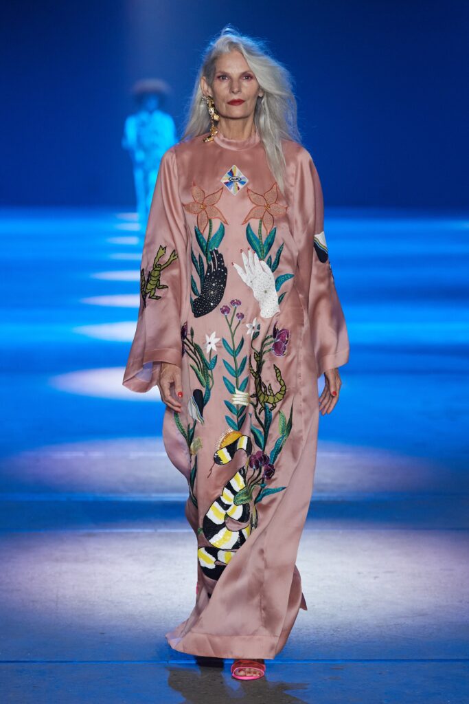A relaxed pink silk dress with long sleeves, a V-neckline, and intricate embroidery.