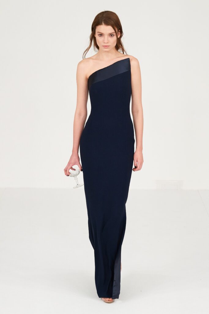 A fitted navy silk sleeveless gown with a high neckline and straight-leg silhouette.