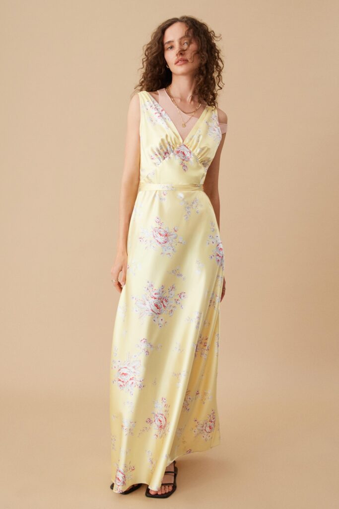 A fitted yellow floral maxi dress with a V-neckline and sleeveless design.