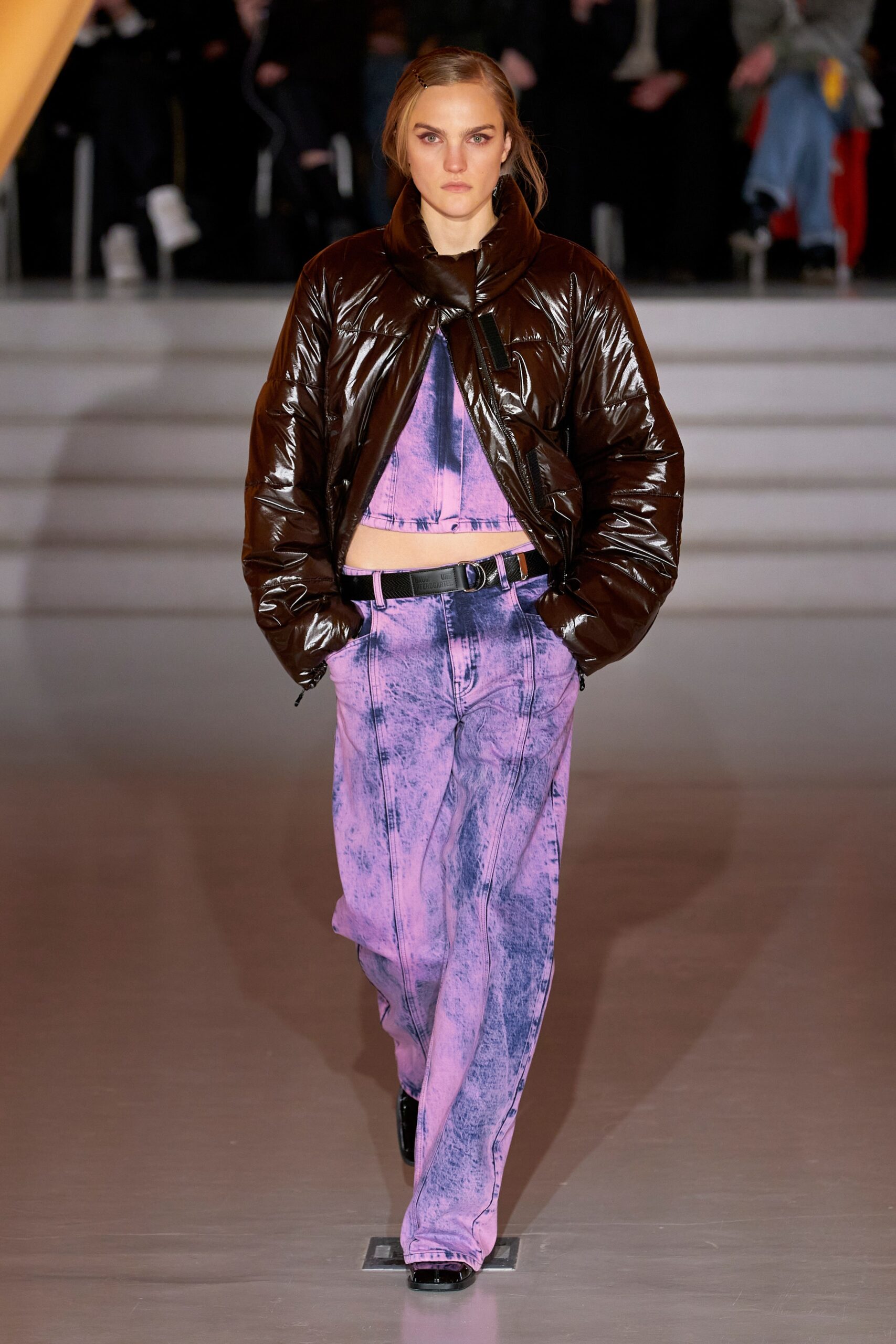 A relaxed brown leather jacket paired with high-waisted printed purple pants.