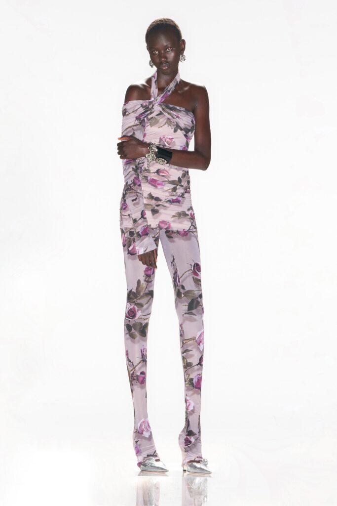 A fitted pink floral sleeveless jumpsuit with a halter neckline.