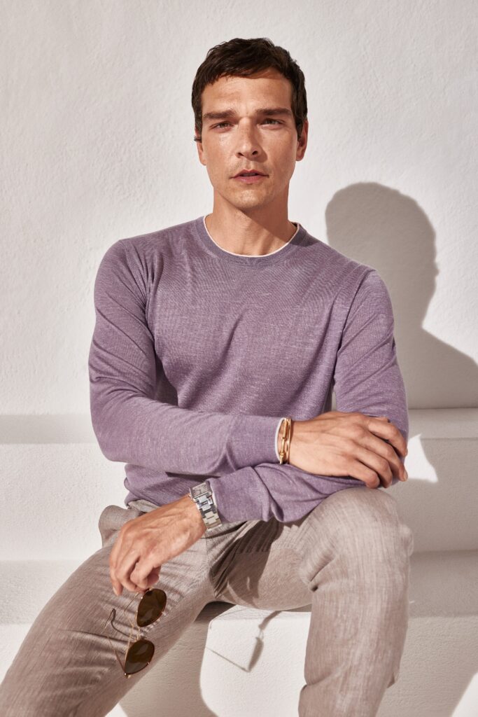 A fitted purple long-sleeve shirt paired with beige straight-leg pants.