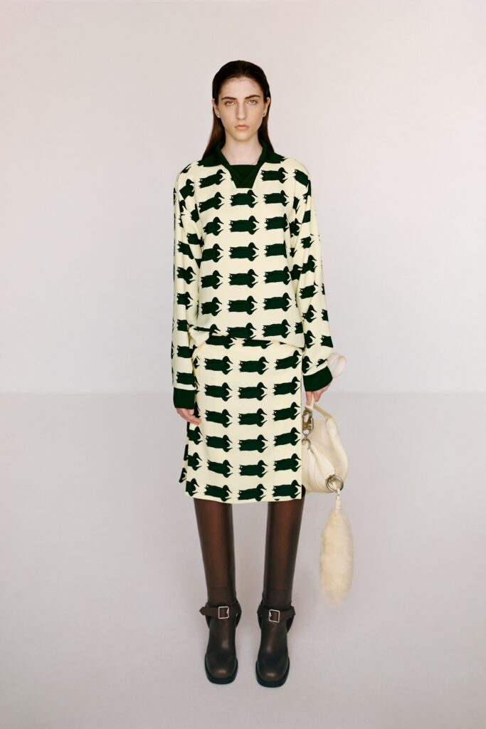 A fitted cream and green printed long-sleeve top paired with a matching skirt.