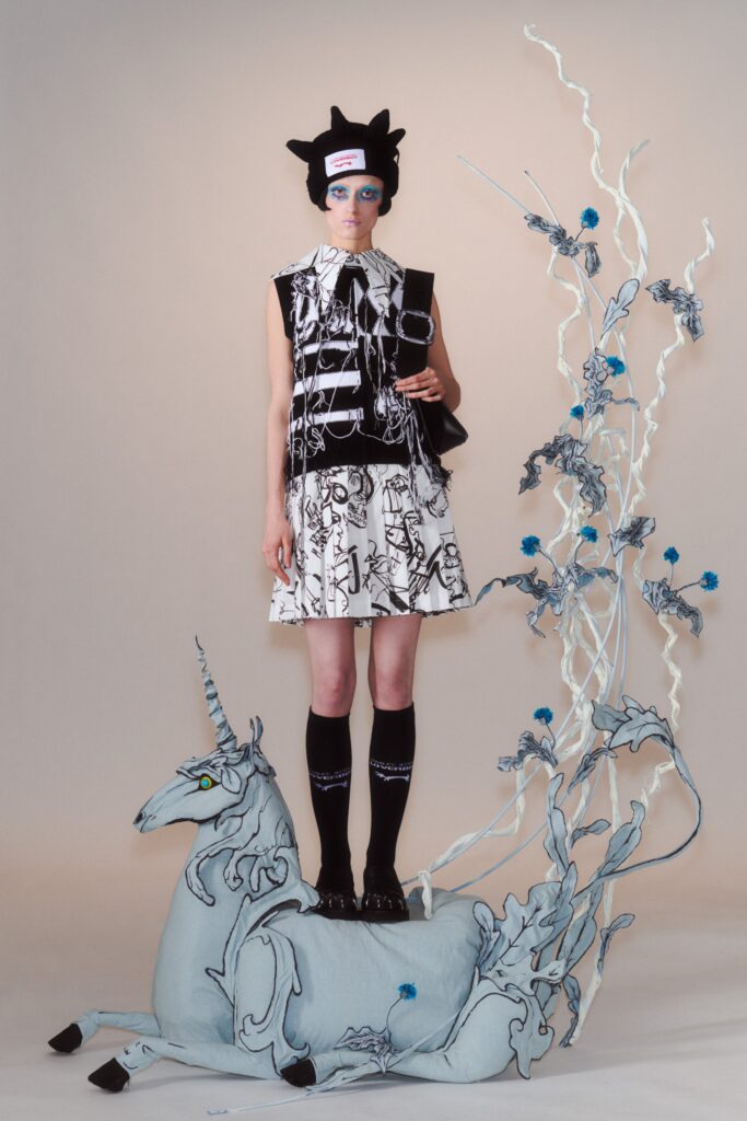 A fitted black and white printed sleeveless dress with a collared design.