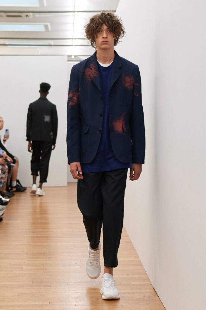 A relaxed blue printed jacket with long sleeves paired with black relaxed-fit pants.