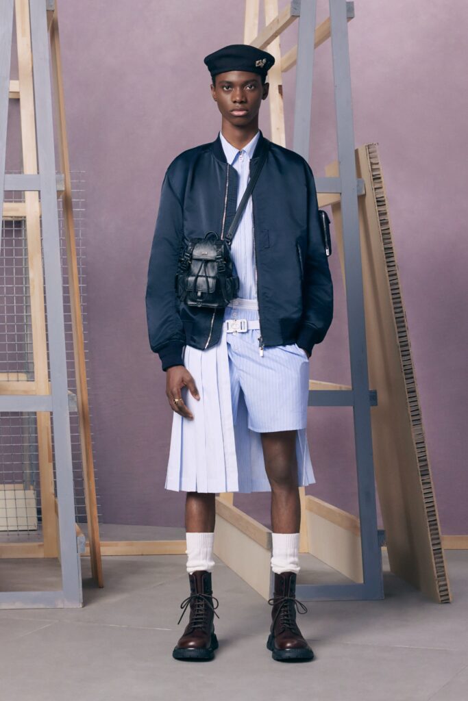 A blue cotton buttoned jacket paired with pleated white shorts for a stylish look.