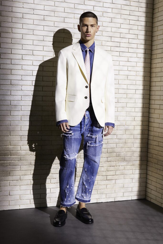 A relaxed white blazer paired with high-waisted distressed blue jeans for a modern look.