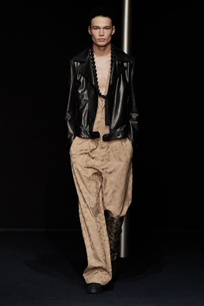 black leather jacket and beige pants