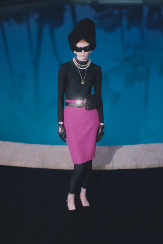 A fitted black long-sleeve top paired with a pencil pink skirt.