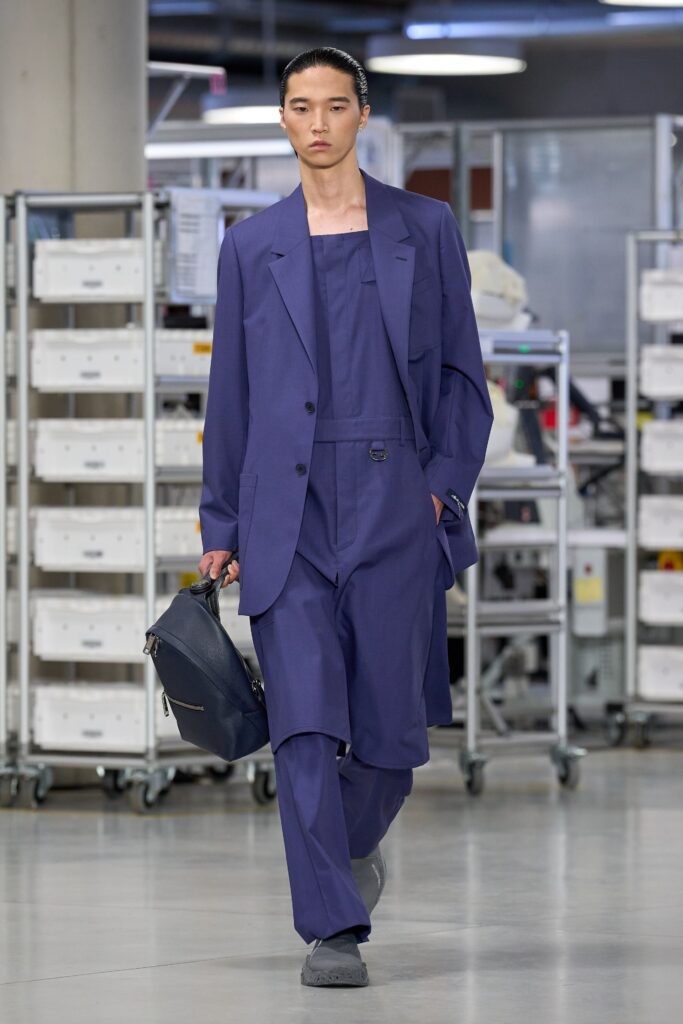 A relaxed blue cotton suit with long sleeves and an asymmetric design detail.