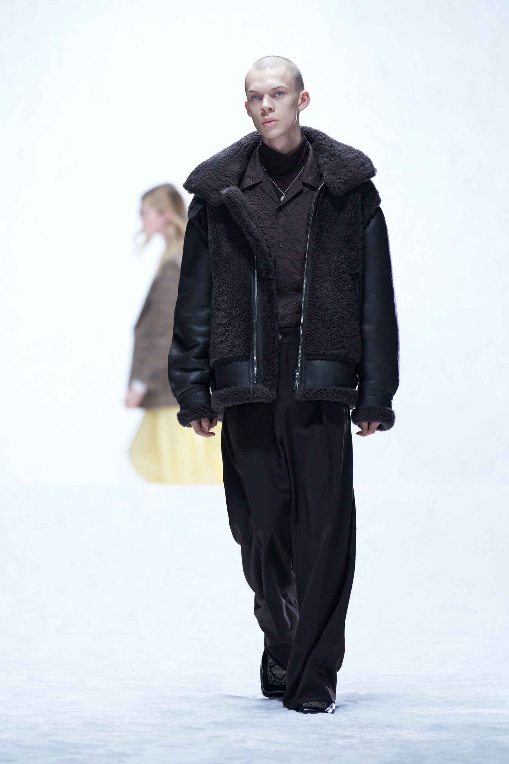 A relaxed black leather jacket with a collared neckline and zippered detail, paired with matching pants.