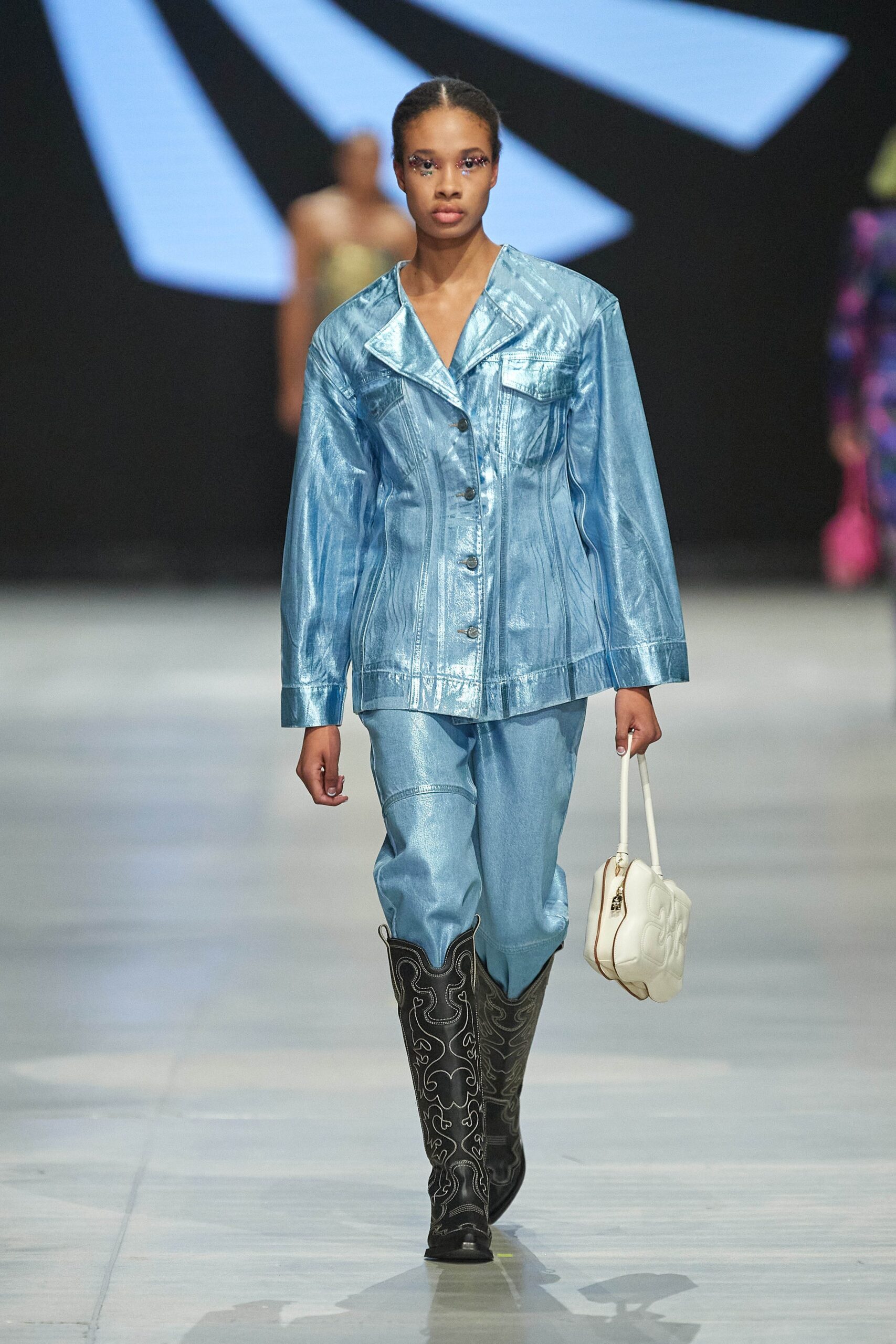 A fitted blue denim jacket with long sleeves and a collared design paired with straight-leg pants.