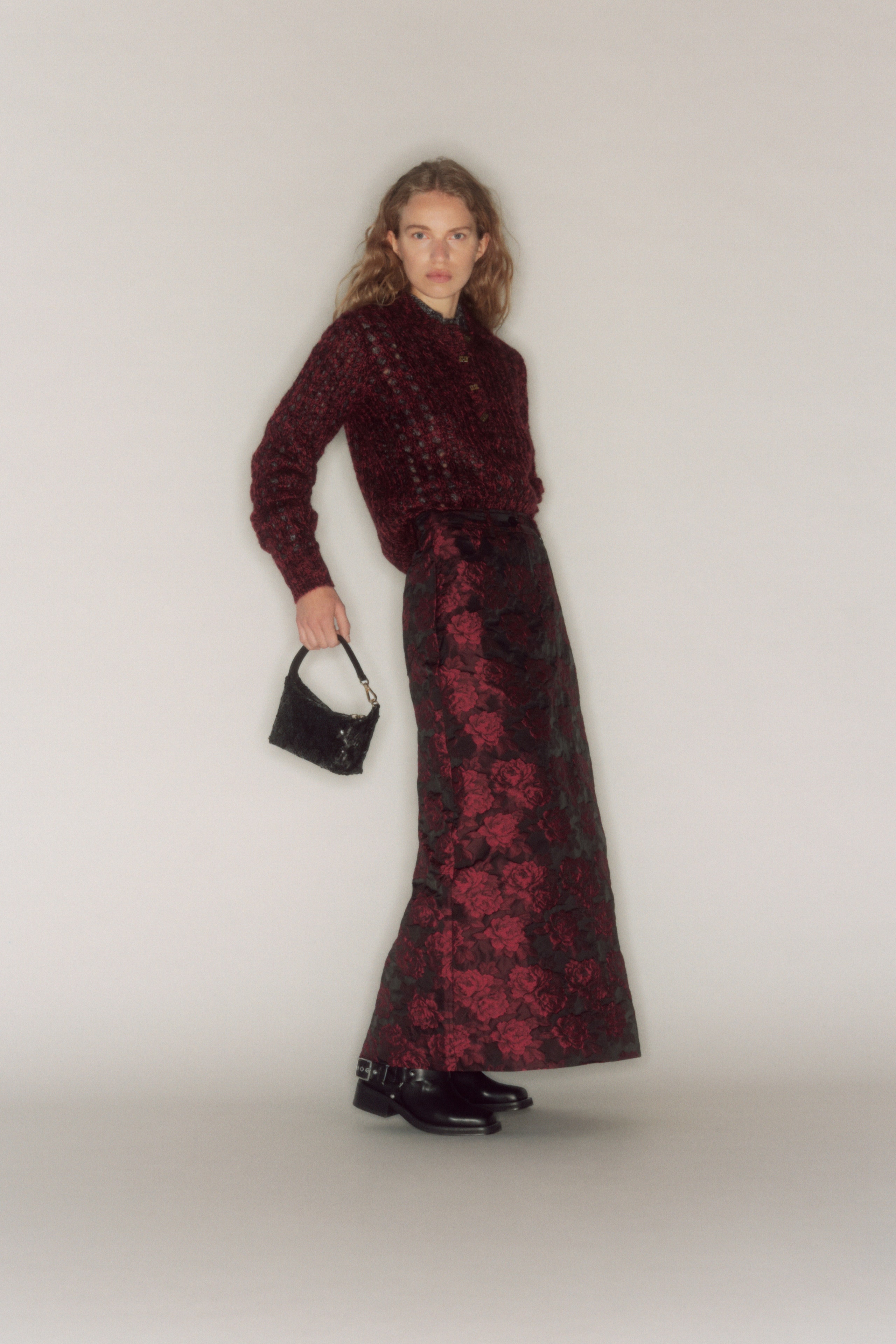 A fitted red silk long-sleeve shirt paired with a flared black skirt.