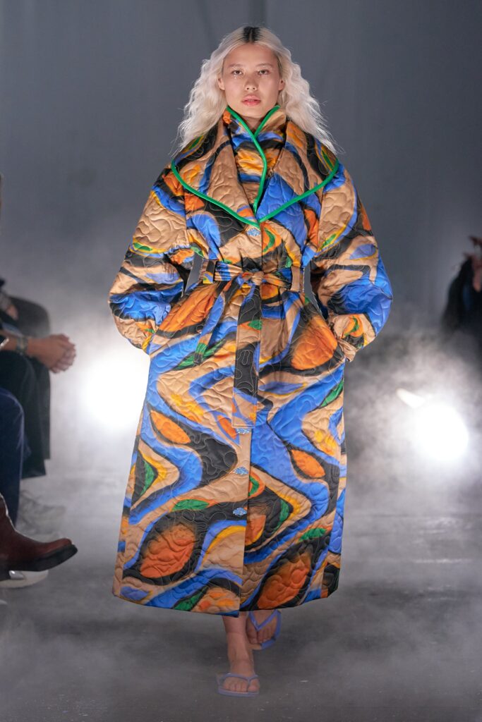 A relaxed multicolor coat with long sleeves, a collared neckline, and a belted design.