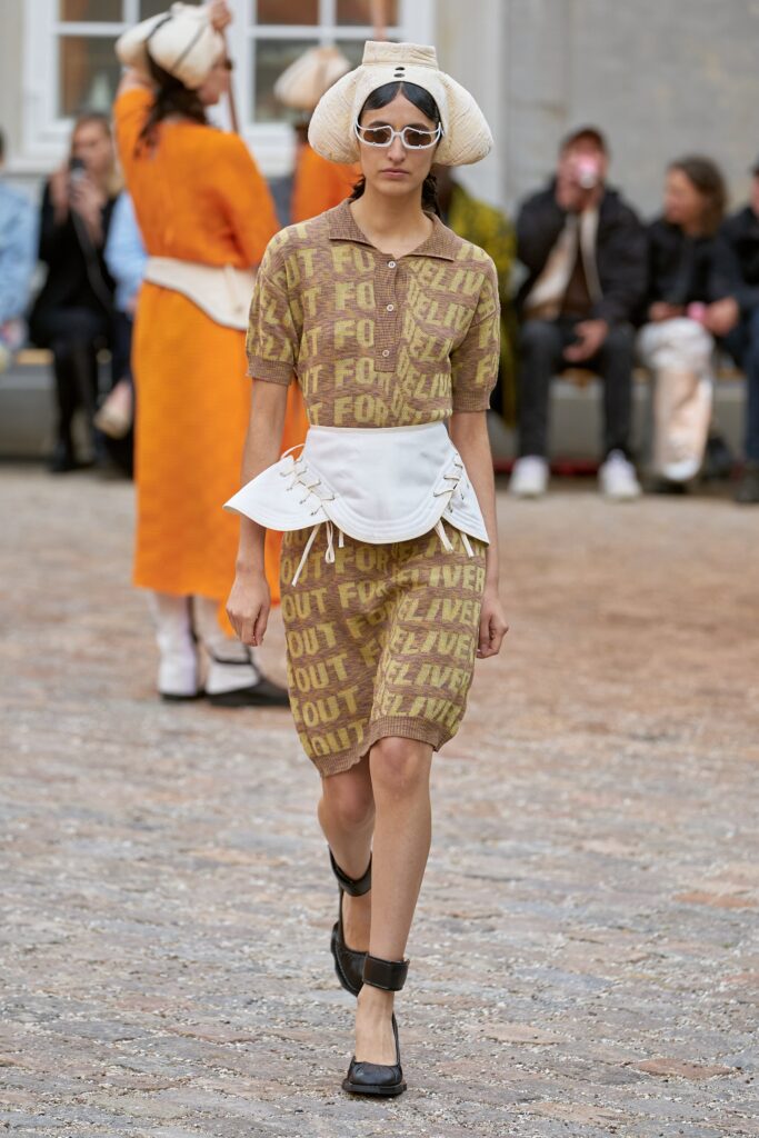 A fitted brown cotton dress with a collared neckline and short sleeves featuring a printed design.
