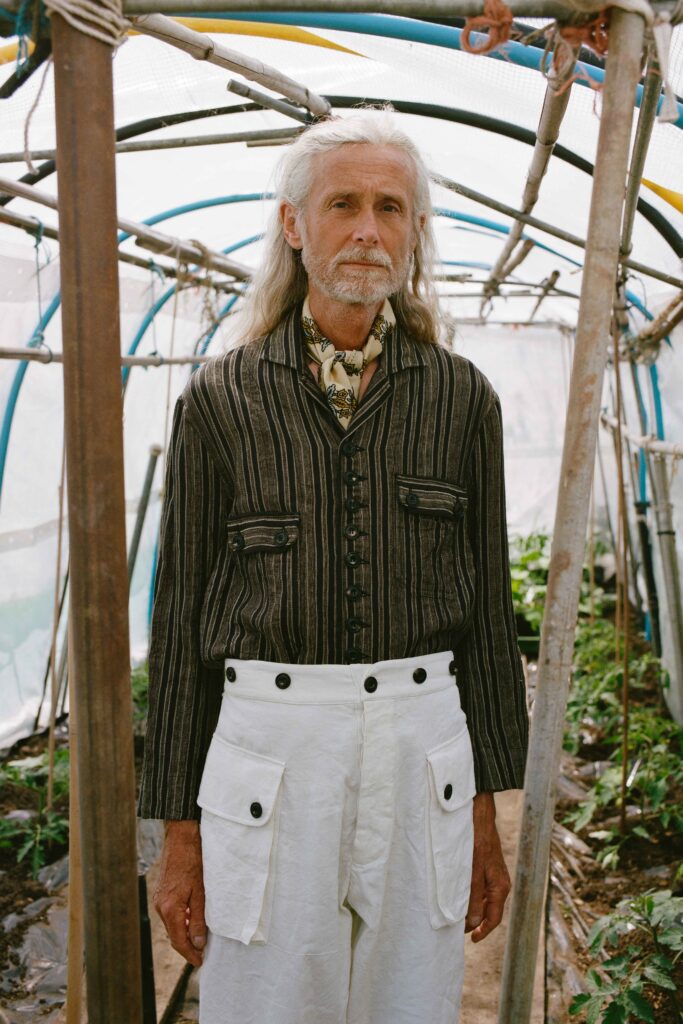 A relaxed black striped long-sleeve shirt paired with white relaxed-fit pants.