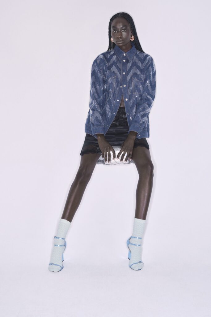 A fitted blue striped long-sleeve shirt with a collared neckline paired with a mini black skirt.