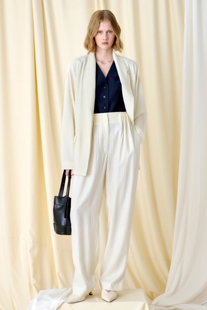 A relaxed white cotton jacket with long sleeves and pleated pants for a chic look.