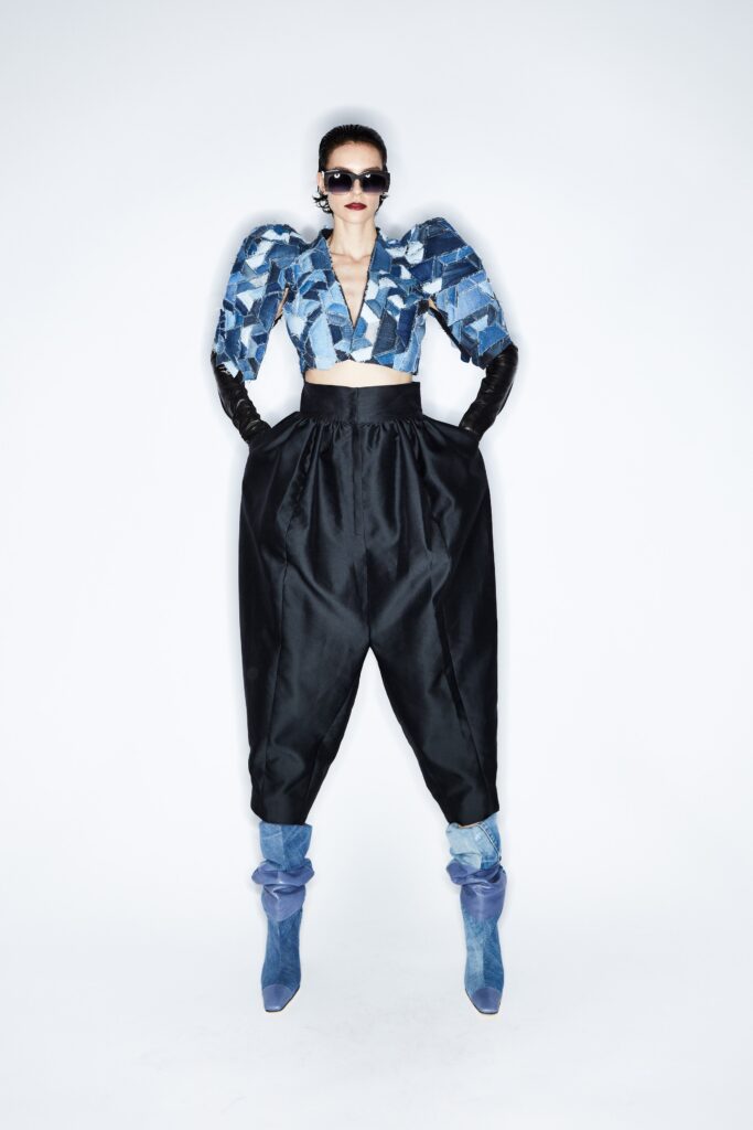A relaxed blue cropped top with long sleeves and asymmetric design paired with black relaxed pants.